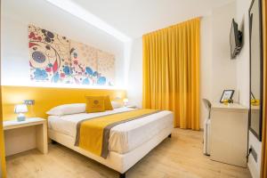 a bedroom with a large bed with yellow curtains at Palazzo San Giovanni in Cava deʼ Tirreni
