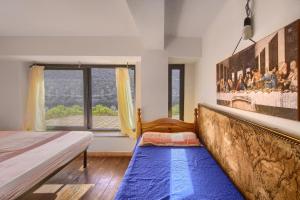 a bedroom with a bed and a large window at Appartamento Panoramico sul Mare in Buggerru