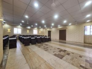 una grande stanza con sedie e tavoli di Hotel Nova Pride a Rajkot