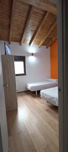 a room with two beds and an open door at Alojamientos playa del silencio in Castañeras