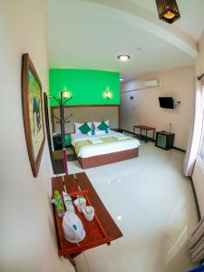 ein Schlafzimmer mit einem großen Bett und einer grünen Wand in der Unterkunft O2 Ella in Ella