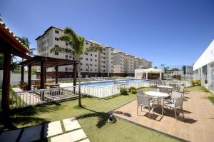 a patio with a table and chairs and a pool at Apartamento em Ilhéus próximo as Praias in Ilhéus