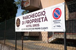ein Schild auf einem Zaun vor einem Gebäude in der Unterkunft Hotel Siros in Verona