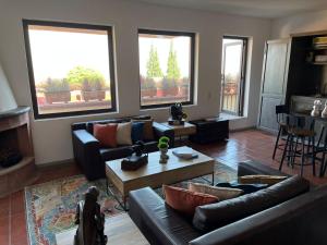 a living room with two couches and a table at Cousy Condo in the historic center of San Miguel de Allende, incredible view, pool, BBQ, 3 blocks from the main parish in San Miguel de Allende