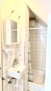 a white bathroom with a sink and a shower at Hotel garni Bad Café Bad Niedernau in Bad Niedernau