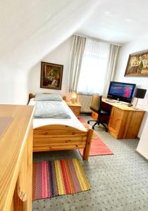 a bedroom with a bed and a desk with a computer at Hotel garni Bad Café Bad Niedernau in Bad Niedernau