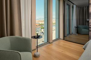 a room with a bed and a chair and a window at Hotel Ambasador in Split