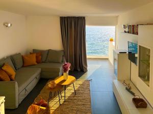 a living room with a couch and a view of the ocean at At the ocean’s edge in Callao Salvaje