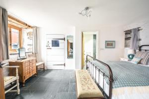 a bedroom with a bed and a desk and a window at St Davids Hideaway with Roll-top Bath & Log Burner in St. Davids