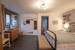 Un dormitorio con una cama, una cómoda y un espejo. en St Davids Hideaway with Roll-top Bath & Log Burner, en St. Davids