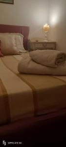 2 Betten in einem Schlafzimmer mit einer Lampe auf einem Tisch in der Unterkunft B&B LEO'S in Cagliari