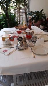 einen weißen Tisch mit Tellern und Küchenutensilien darauf in der Unterkunft B&B LEO'S in Cagliari