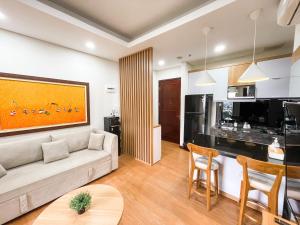 2 Bedrooms Permata Hijau Suites Apartment في جاكرتا: غرفة معيشة مع أريكة ومطبخ