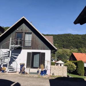 ein kleines weißes Haus mit schwarzem Dach in der Unterkunft Ferienwohnung Klenk in Gruibingen