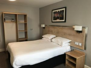 um quarto com uma grande cama branca e uma cabeceira em madeira em Crown, Droitwich by Marston's Inns em Droitwich Spa