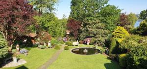 einen Blick über einen Garten mit einem Teich und einer Brücke in der Unterkunft Ferien im Königshaus in Möhnesee
