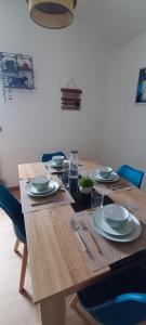 a wooden table with plates and dishes on it at La Belle Rive du voyageur in Bellerive-sur-Allier