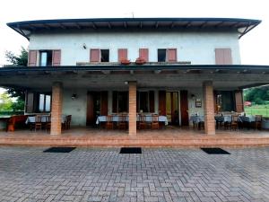 budynek ze stołami i krzesłami na patio w obiekcie B&B Torrechiara w mieście Torrechiara