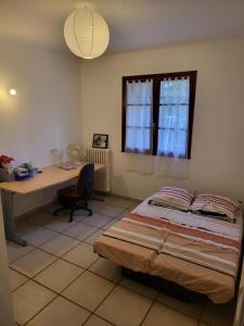 a bedroom with a bed and a desk and a window at Grande maison avec 5 chambres et jardin in Avignon