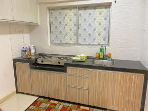uma cozinha com um fogão, um lavatório e uma janela em 9293 Taman Sri idaman em Ayer Itam