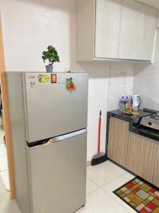 a kitchen with a refrigerator with a plant on top of it at 9293 Taman Sri idaman in Ayer Itam
