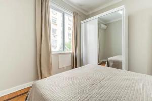 里約熱內盧的住宿－Apartamento Epitácio Pessoa，一间卧室配有一张床和一面大镜子