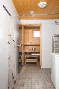a sauna with a table and a chair in a room at Alppitähti, Huoneisto Hilla in Levi