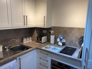 - une cuisine avec des placards blancs et un évier dans l'établissement Number 10 Serviced Apartment - Chapel, à Southampton