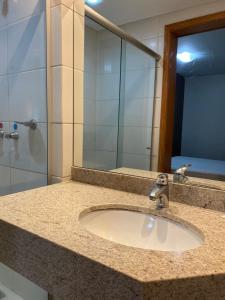 a bathroom counter with a sink and a mirror at 712 - FLAT para temporada em Goiania-proximo ao Parque Areião in Goiânia