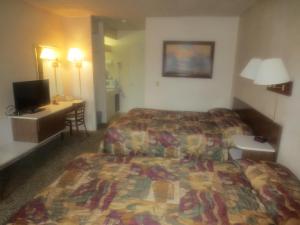 Habitación de hotel con 2 camas y TV en Downtowner Inn, en Grangeville
