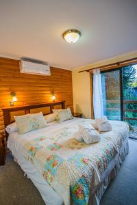 a bedroom with a large bed with pillows on it at Hotel Termas de San Luis in Pucón +40 photos
