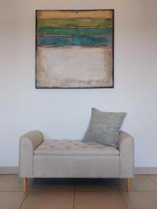 a couch in a room with a painting on the wall at Duplex Villa Capricia appartement met zwembad Nieuwpoort Jachthaven in Nieuwpoort