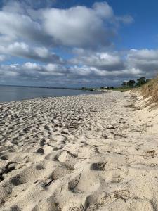 une plage de sable avec des empreintes de pieds dans le sable dans l'établissement Mysigt rum i villa med egen ingång och nära havet., à Åhus