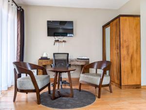 a living room with a table and two chairs and a television at Valiha Hotel Antananarivo in Antananarivo