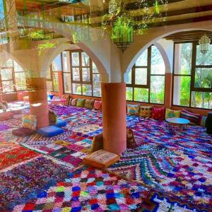 a large room with a colorful carpeted floor with windows at ferme by Ikalimo in Ourika