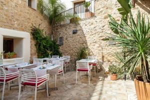 a restaurant with white tables and chairs in a courtyard at Casa Rural Lliber in Lliber