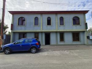 a blue car parked in front of a house at Gricko in Tbilisi City
