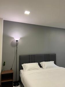 - une chambre avec un grand lit blanc et une lampe dans l'établissement see-on place/สีอ่อนเพลส, à Ban Tha Phae