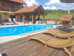 a swimming pool with two lounge chairs next to a house at Lahinja & Kolpa river apartments in Metlika