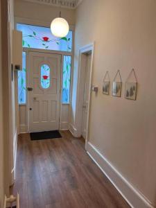 an empty hallway with a door with stained glass at Victorian 3 BR main door flat, King size beds , large rooms in Glasgow