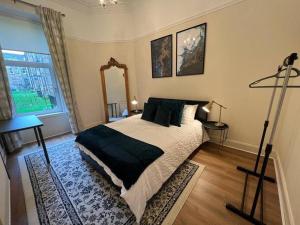 a bedroom with a large bed and a window at Victorian 3 BR main door flat, King size beds , large rooms in Glasgow