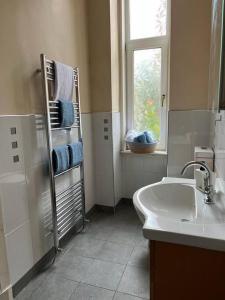 a white bathroom with a sink and a window at Victorian 3 BR main door flat, King size beds , large rooms in Glasgow