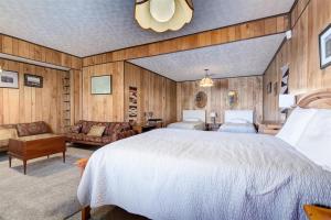 a bedroom with a large white bed and wooden walls at Melton Away - Knoxville/Oak Ridge in Knoxville +26 photos