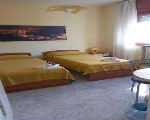 a hotel room with two beds and a table at B&B Viale delle Colline in Salerno