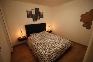 ein Schlafzimmer mit einem Bett und zwei Lampen an Tischen in der Unterkunft Châtel - Appartement 4-6 personnes - Les Châlets des Freinets C203 in Châtel