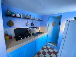 a blue kitchen with a sink and a blue wall at Dar Lazrak in Chefchaouen