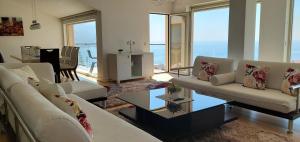 a living room with white furniture and a view of the ocean at Spa Resort Luxury Apartments in Budva