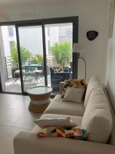 sala de estar con 2 sofás blancos y balcón en Joli appartement coquet et cosy, en Royan