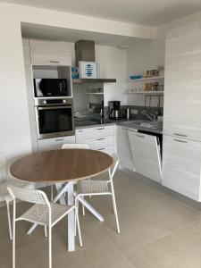 una cocina con mesa de madera y sillas. en Joli appartement coquet et cosy en Royan