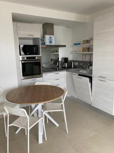 kuchnia z drewnianym stołem i krzesłami w obiekcie Joli appartement coquet et cosy w mieście Royan